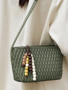 Dark green quilted shoulder bag with beaded charm and adjustable strap for women