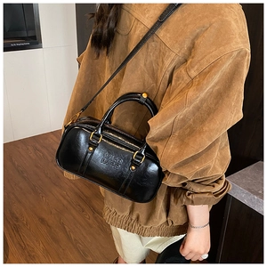 Detail of black glossy leather Boston bag with gold zipper and embossed MRR MRR logo