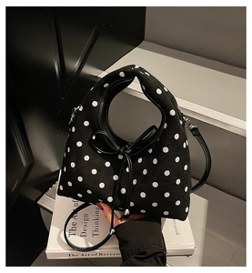Vue détaillée du sac à main noir à pois avec noeud décoratif et bandoulière chic
