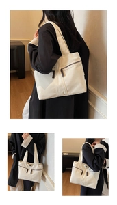 Detail view of the cream canvas tote bag with functional double front zipper pockets