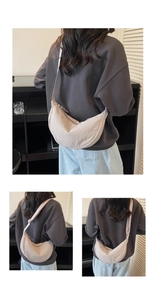 Detail view of the cream crescent bag showing premium nylon texture and wide strap