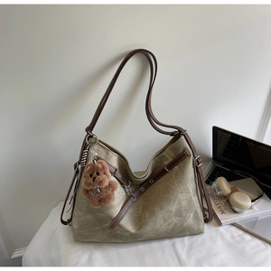 Retro khaki tote bag detail with brown leather strap and cute bear plush charm decoration