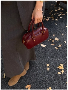Detail shot of vintage burgundy bowling bag with leather texture and top handles