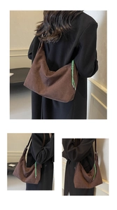 Detail of a brown suede hobo bag with a distinctive green woven decorative strap detail