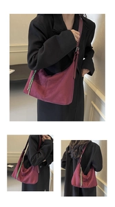 Detail view of burgundy suede hobo bag with distinctive green braided rope accents