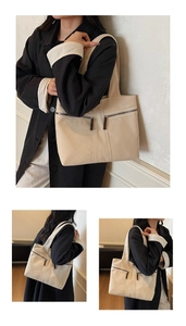 Close-up of off-white canvas tote bag with front dual zipper pockets and leather pulls