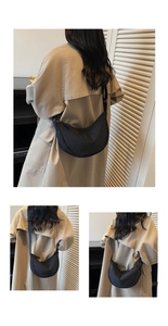 Detailed view of black nylon half-moon crossbody bag with adjustable fabric shoulder strap
