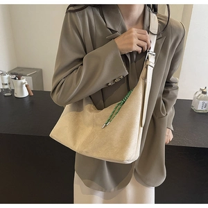 Detail of light beige crescent hobo bag with unique green drawstring and silver buckle