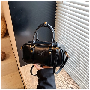 Detail of black matte leather Boston bag with vintage gold hardware and logo embossing