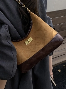 Chic quilted rhombic chain bag in yellow and brown leather on a wooden bench