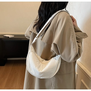 Side view of white crescent shoulder bag in nylon fabric on a female model