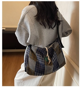 Detail view of large plaid tote bag showing side drawstring and fabric texture