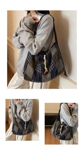 Detailed view of large plaid canvas shoulder bag with rope buckle and heart charm