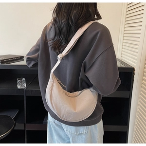 Detailed back view of a light gray crescent crossbody bag with adjustable wide strap