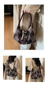 Detail of tweed plaid tote bag featuring a beige drawstring and dark toggle button closure