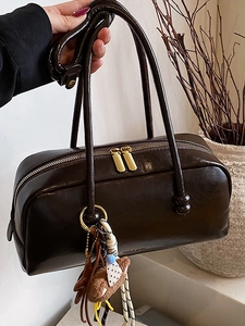 Deep brown glossy Boston handbag with long straps and a cute teddy bear charm