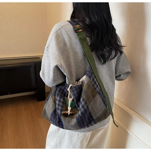 Detail of plaid tote bag with wooden toggle closure and green heart pendant