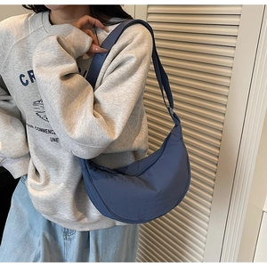 Detail of smog blue crescent crossbody bag with adjustable wide strap and zip closure