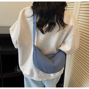 Detailed view of Morandi blue nylon crescent bag with wide adjustable shoulder strap