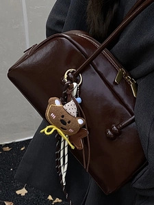 Minimalist vintage dark brown leather bowling bag with cute plush bear charm for women