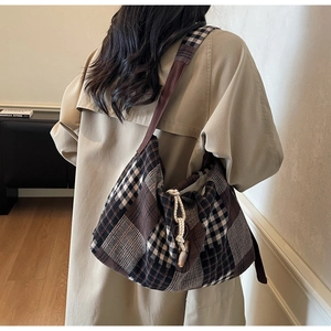 Detail of checkered plaid hobo bag with drawstring closure and vintage toggle button