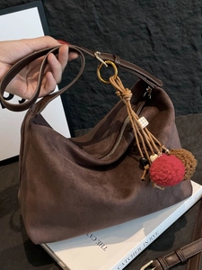 Braune Hobo-Tasche aus mattem Wildleder mit Umhängegurt und dekorativem Anhänger