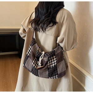 Close-up of vintage plaid tweed tote bag featuring wooden horn button closure and texture