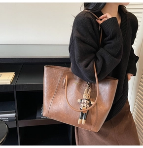 Detail of vintage brown tote bag with textured faux leather and a cute bunny charm