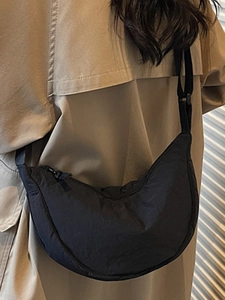 Minimalist black nylon crescent crossbody bag with adjustable strap and pleated texture