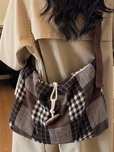 Plaid canvas tote bag with horn buckle and heart detail worn with khaki trench coat