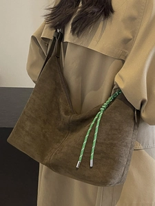 Minimalist large brown tote bag with woven strap shown on model in autumn trench coat
