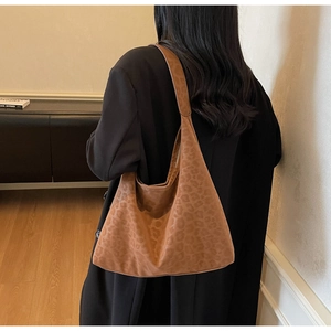 Brown leopard print hobo bag with matte texture shown in use by model from a side angle