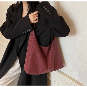 Detail of burgundy leopard print hobo bag in matte suede with textured leopard embossing