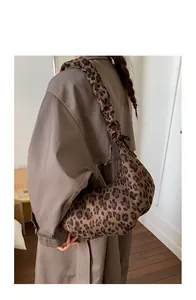 Detail of leopard print tote bag with pleated shoulder strap shown on a model