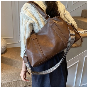 Detail view of vintage brown Boston bag with a stylish ethnic woven wide shoulder strap