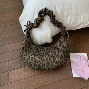 Detail of hobo bag with leopard print, suede texture, and stylish bow on gathered handle