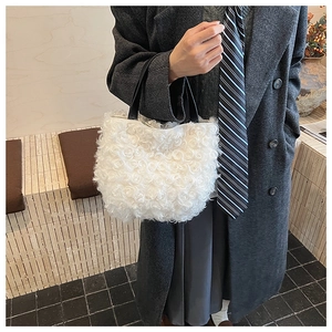 Close-up of white rose texture faux fur bucket bag with contrast black leather handles