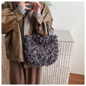 Detailed texture of gray faux fur bucket bag with black leather handle on model
