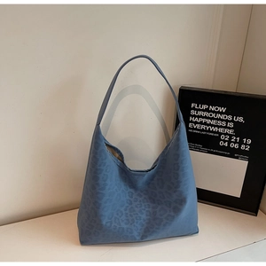 Detail of blue leopard print hobo bag showing the textured matte canvas fabric and pattern