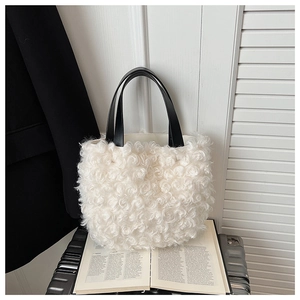 Detail of white faux fur bucket bag featuring textured sherpa fabric and black handles