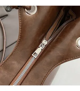 Detailed close-up of the smooth silver zipper and stitching on the brown vintage tote bag