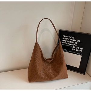 Detailed close-up of brown leopard print tote bag with matte suede texture and shoulder strap