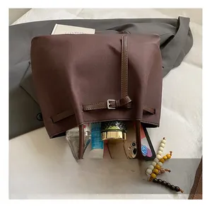 Detail of spacious dark brown leather tote interior with buckle and beaded charm accessory