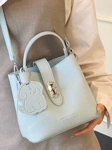 Light blue minimalist bucket bag with litchi texture and cute puppy charm detail