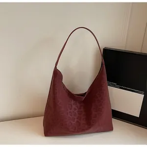 Close-up of matte dark red leopard pattern on a hobo shoulder bag with a soft texture