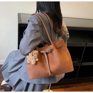 Brown faux suede tote bag featuring a cute plush bear pendant and long shoulder straps