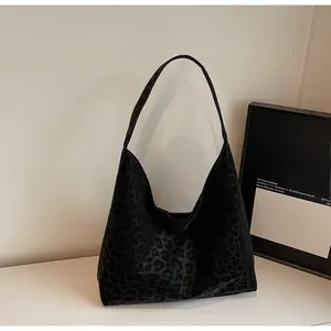 Detail of black leopard print texture on a large capacity satin hobo shoulder tote bag