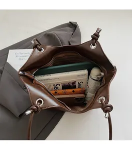 Detail view of large interior space and striped lining in brown leather tote bag