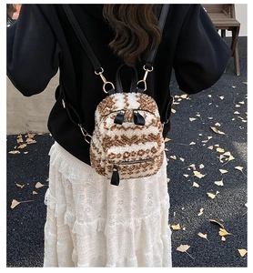 Détails du tissu pelucheux ondulé et des bretelles en cuir noir du mini sac à dos