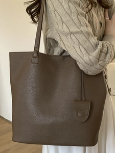 Minimalist large coffee tote bag in pebbled faux leather with matching decorative pendant